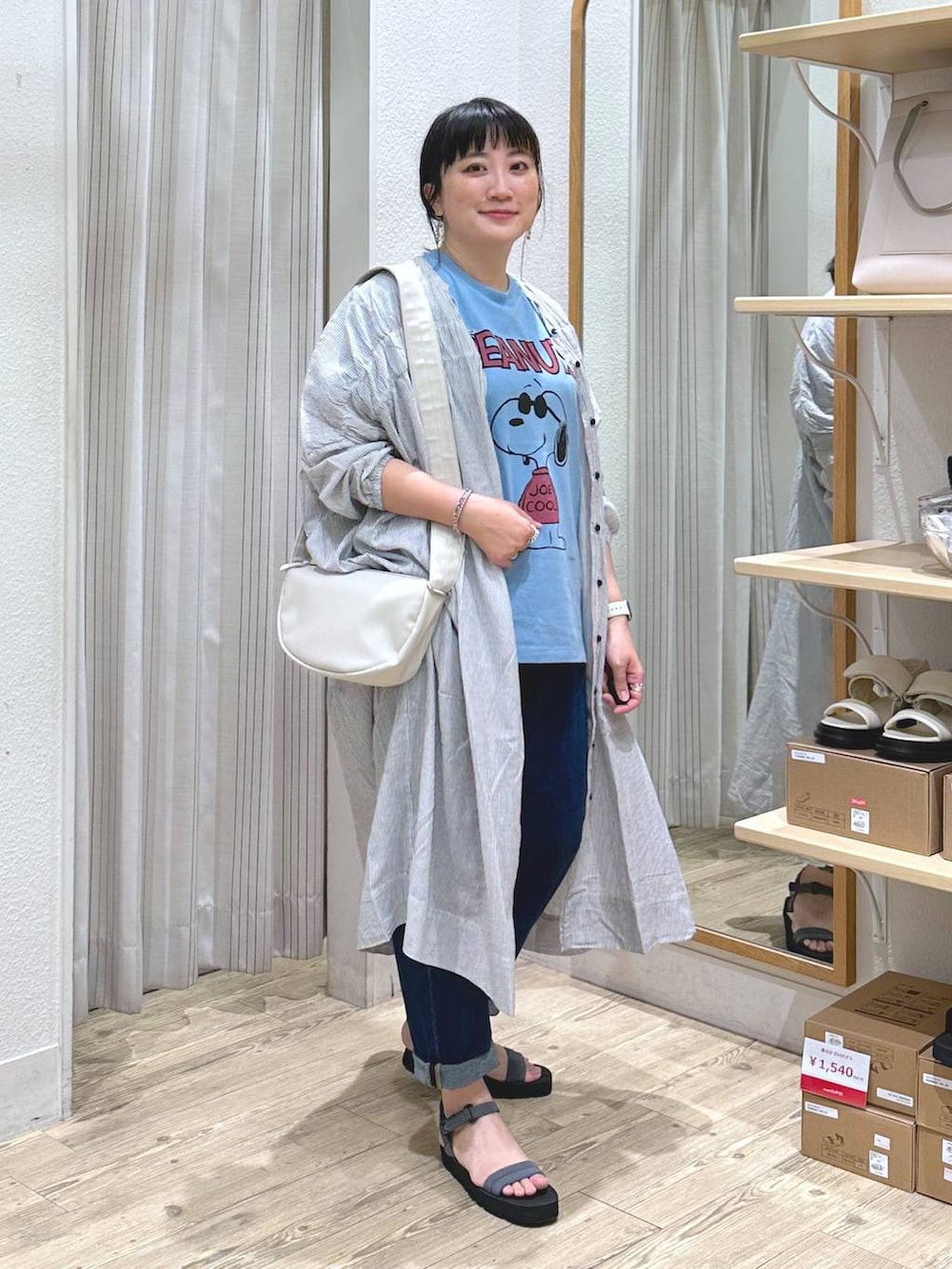 ブラック系のワンピース、ベージュ系のショルダーバッグ、グレー系のサンダルを着用したレディースの夏コーディネートの2枚目の写真