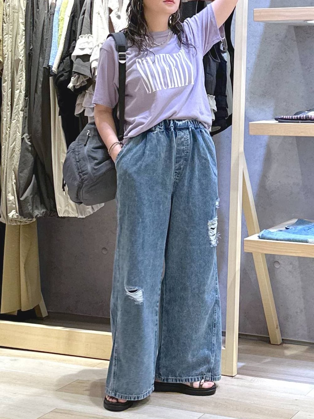 ブルー系のデニムパンツ、ブラウン系のサンダル、グレー系のバックパック/リュックを着用したレディースの夏コーディネートの6枚目の写真
