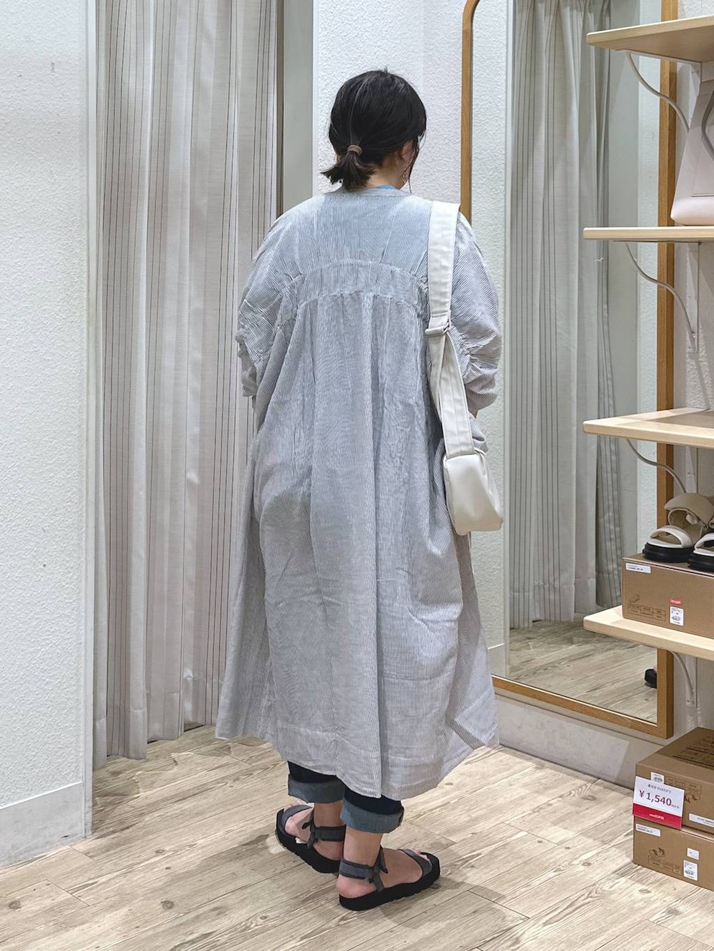 ブラック系のワンピース、ベージュ系のショルダーバッグ、グレー系のサンダルを着用したレディースの夏コーディネートの4枚目の写真