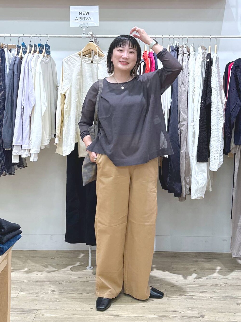 ベージュ系のチノパンツ、ブルー系のノーカラージャケット、ブラウン系のタンクトップを着用したレディースの秋コーディネートの3枚目の写真