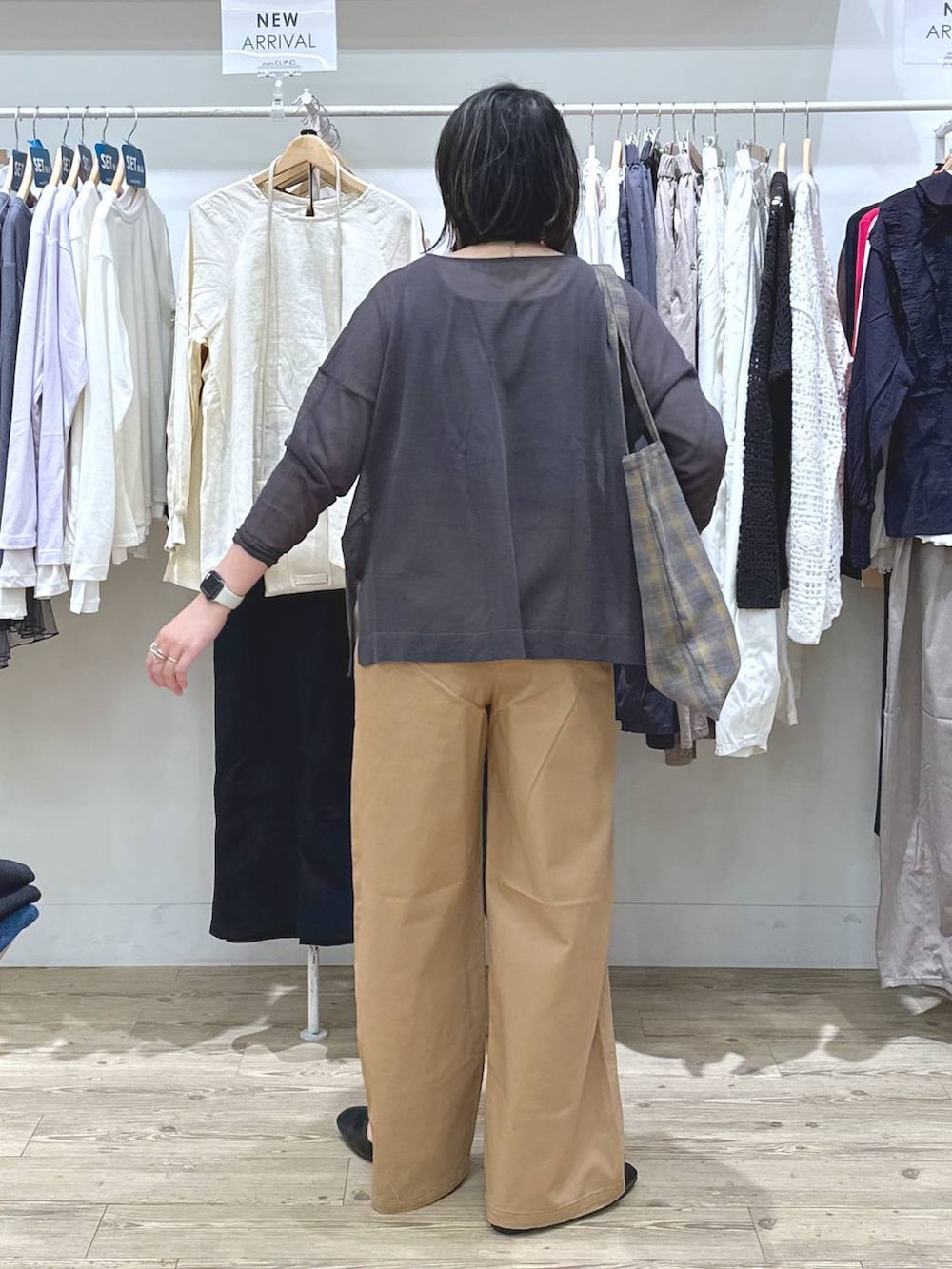 ベージュ系のチノパンツ、ブルー系のノーカラージャケット、ブラウン系のタンクトップを着用したレディースの秋コーディネートの4枚目の写真