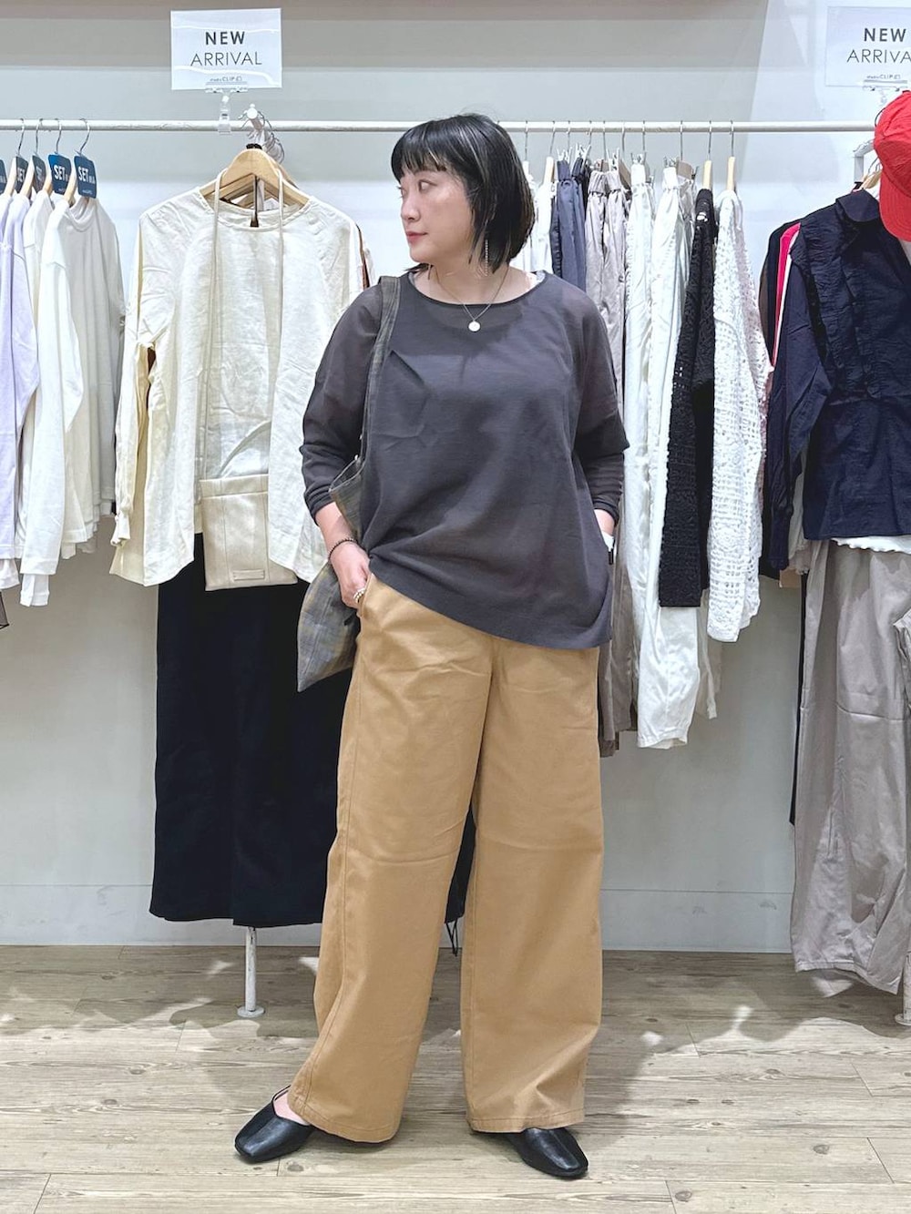 ベージュ系のチノパンツ、ブルー系のノーカラージャケット、ブラウン系のタンクトップを着用したレディースの秋コーディネートの2枚目の写真