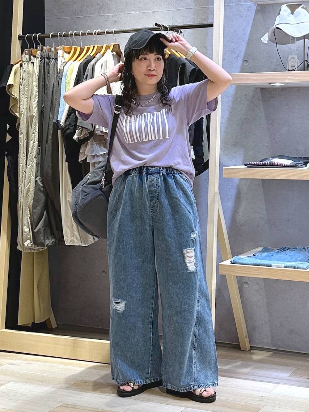 ブルー系のデニムパンツ、ブラウン系のサンダル、グレー系のバックパック/リュックを着用したレディースの夏コーディネートの5枚目の写真