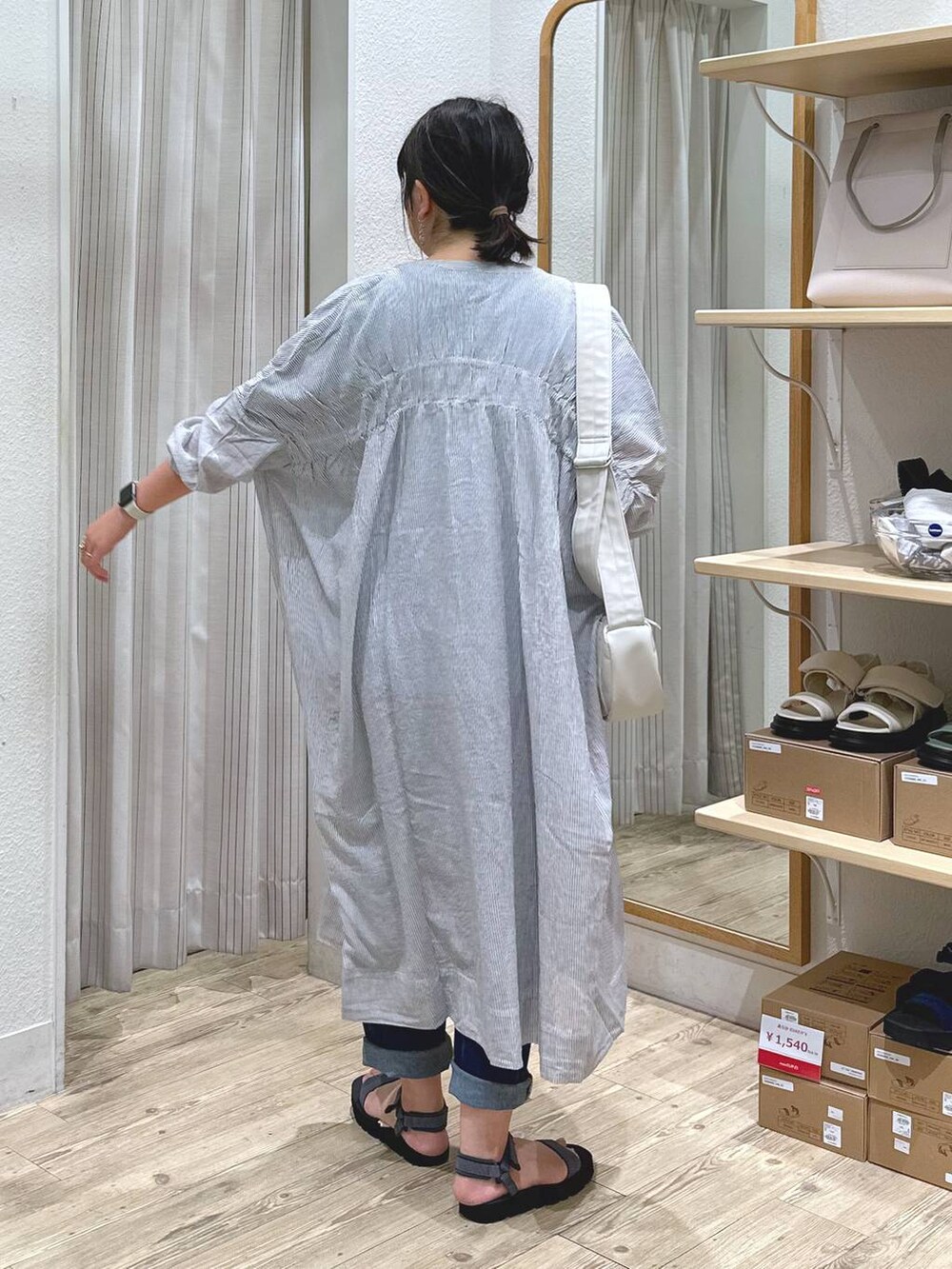 ブラック系のワンピース、ベージュ系のショルダーバッグ、グレー系のサンダルを着用したレディースの夏コーディネートの5枚目の写真