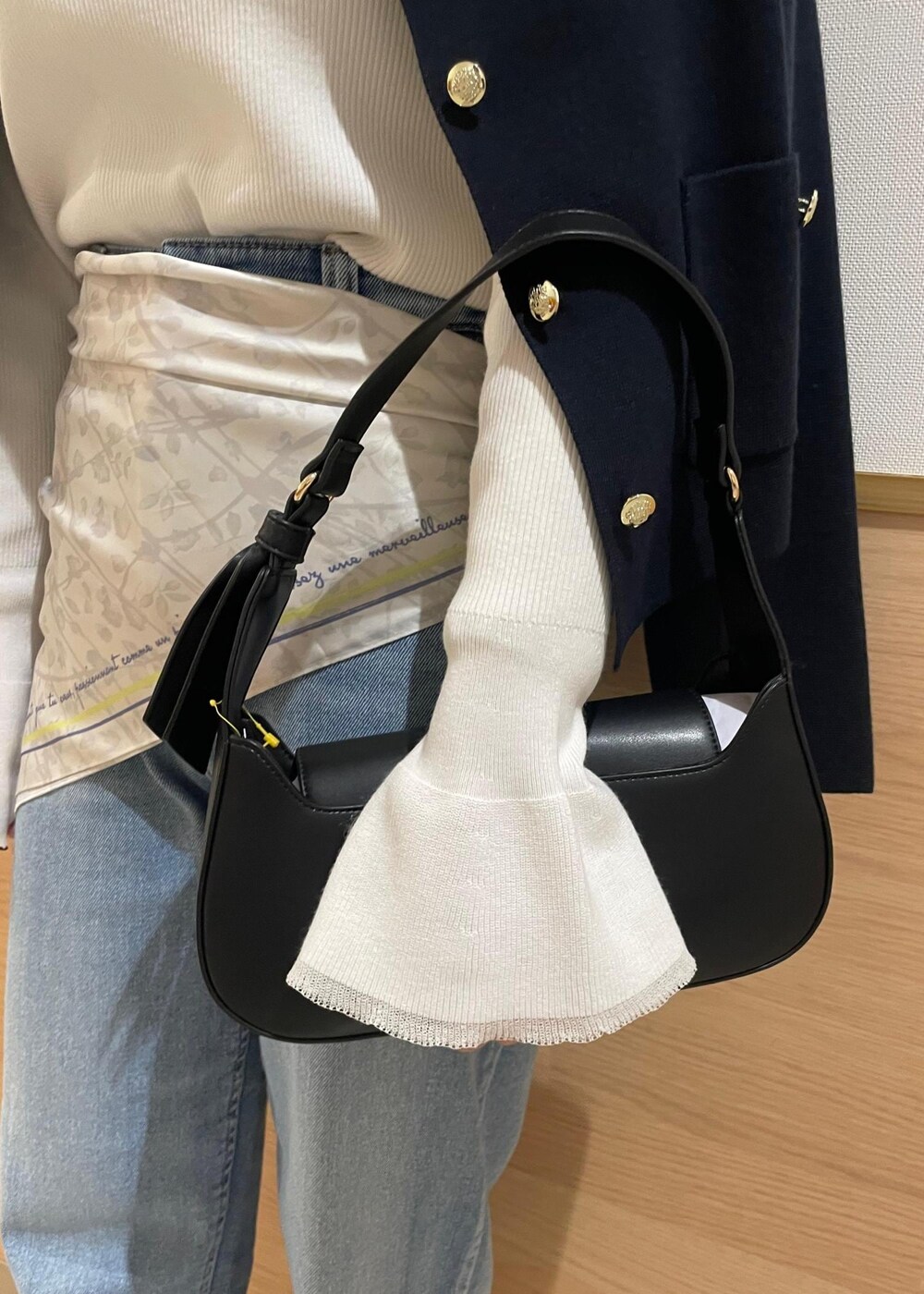 ブルー系のカーディガン/ボレロ、ホワイト系のニット/セーター、ブラック系のハンドバッグを着用したレディースの春コーディネートの9枚目の写真