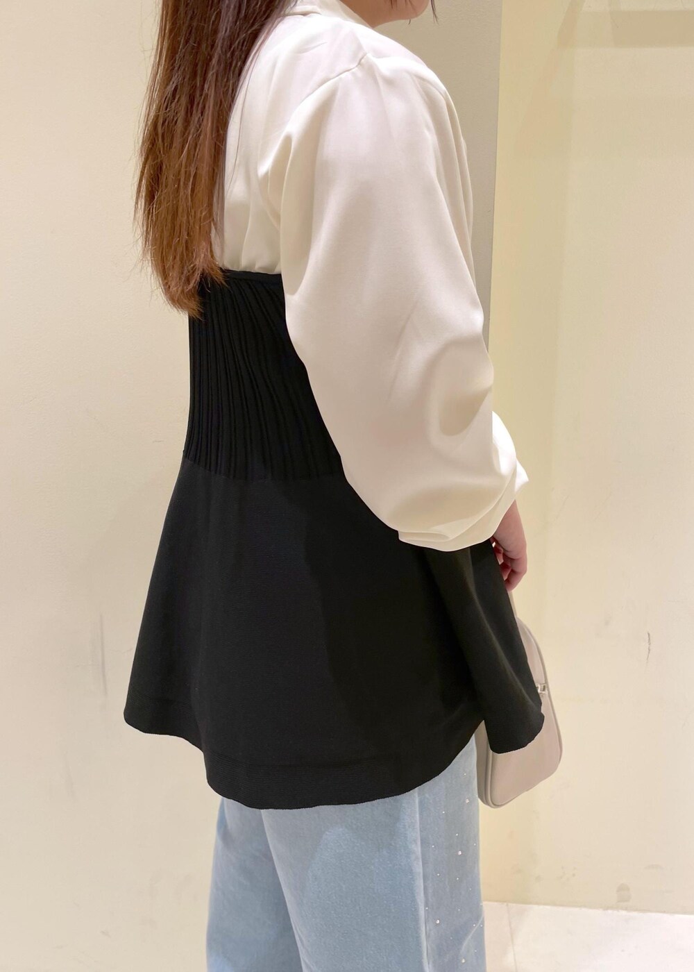 ブルー系のデニムパンツ、ベージュ系のボストンバッグ、ブラック系のパンプスを着用したレディースの秋コーディネートの7枚目の写真