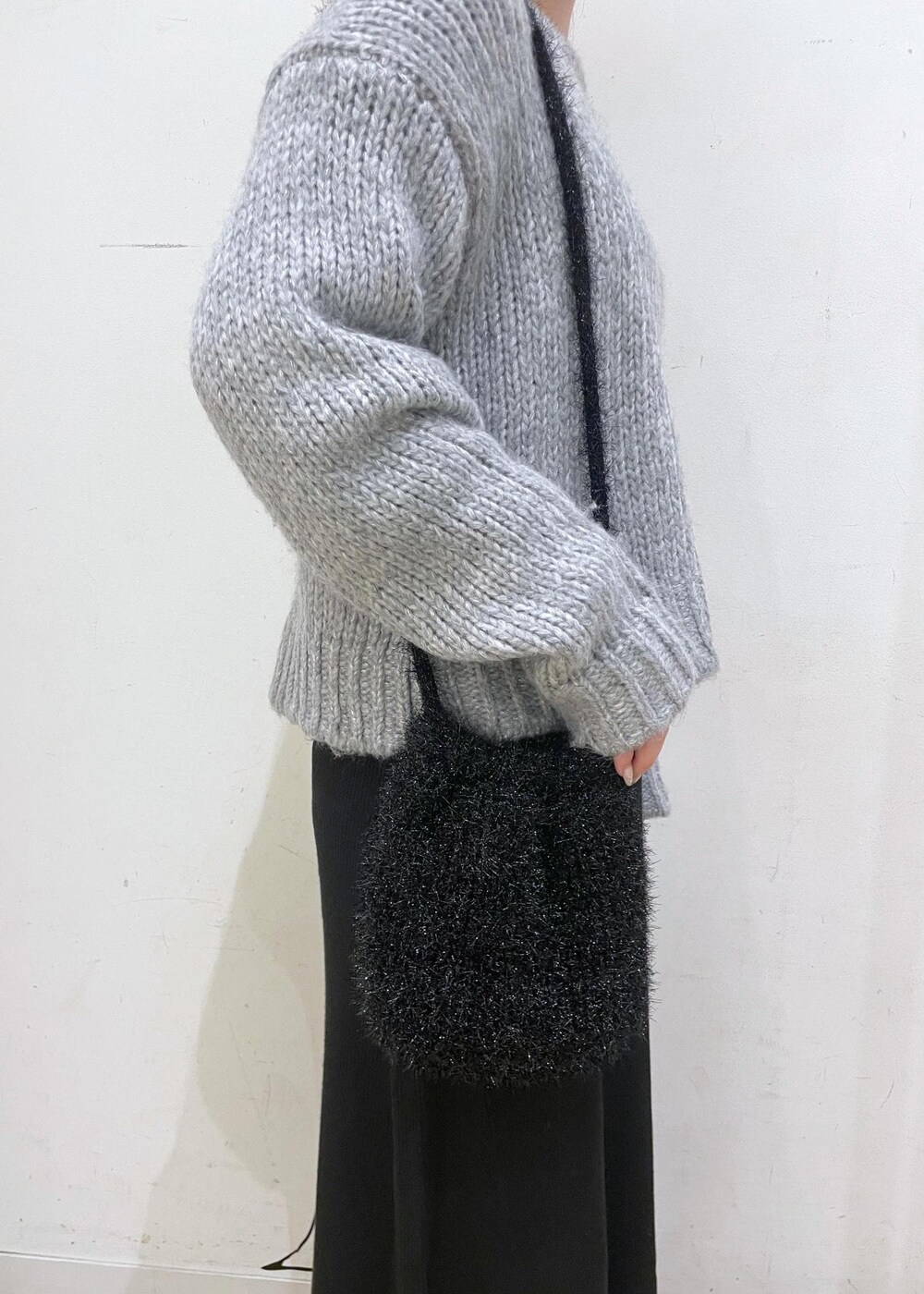 ブラック系のワンピース、ブラック系のショルダーバッグ、グレー系のニット/セーターを着用したレディースの冬コーディネートの6枚目の写真