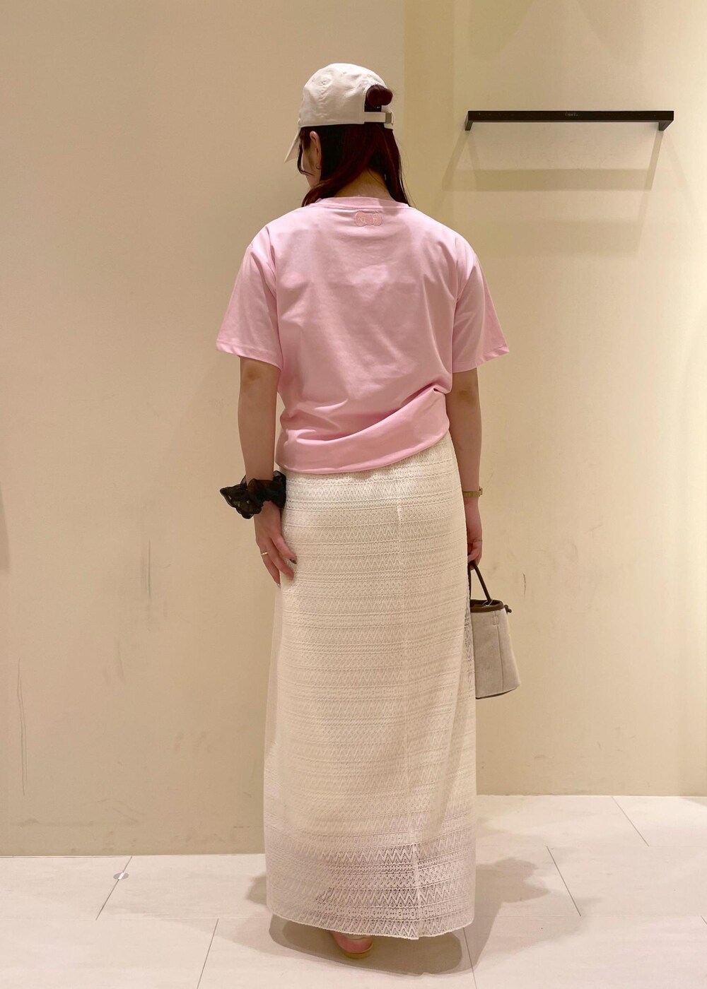 ホワイト系のスカート、ゴールド系のサンダル、ブラウン系のトートバッグを着用したレディースの夏コーディネートの3枚目の写真