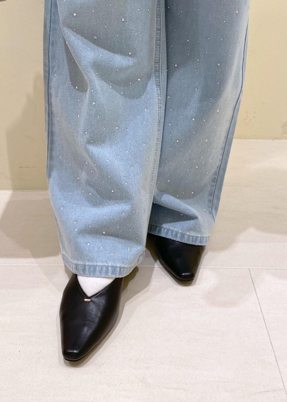 ブルー系のデニムパンツ、ベージュ系のボストンバッグ、ブラック系のパンプスを着用したレディースの秋コーディネートの10枚目の写真