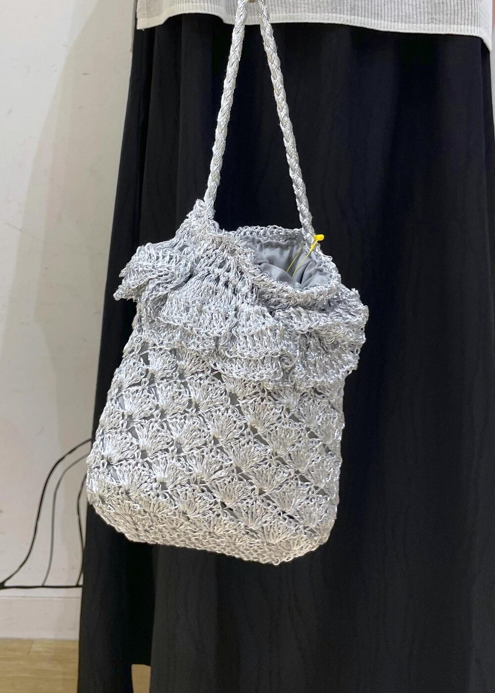 シルバー系のサンダル、シルバー系のショルダーバッグ、ホワイト系のニット/セーターを着用したレディースの夏コーディネートの7枚目の写真