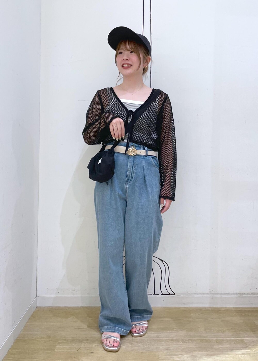 シルバー系のサンダル、ブラック系のショルダーバッグ、ホワイト系のタンクトップを着用したレディースの夏コーディネートの4枚目の写真