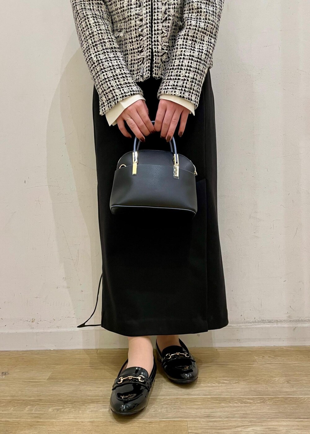 ブラック系のスカート、ホワイト系のシャツ/ブラウス、ブラック系のショルダーバッグを着用したレディースの冬コーディネートの3枚目の写真