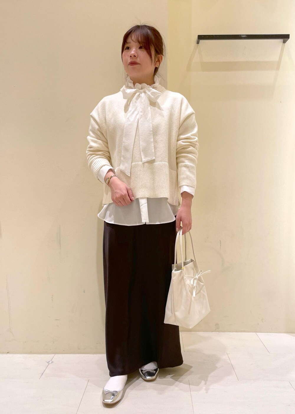 シルバー系のバレエシューズ、ホワイト系のニット/セーター、ホワイト系のトートバッグを着用したレディースの冬コーディネートの10枚目の写真