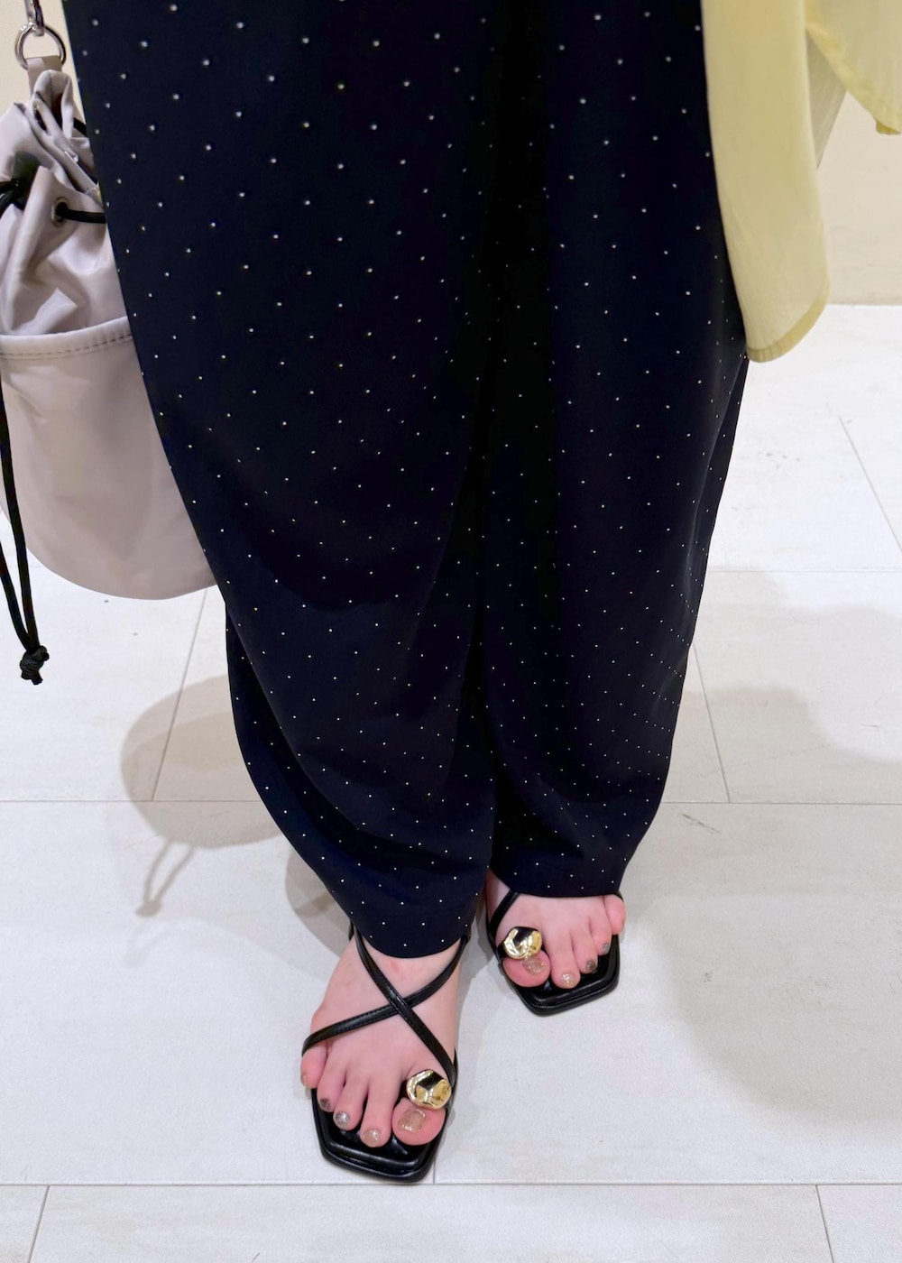 ブラック系のショルダーバッグ、イエロー系のシャツ/ブラウス、ホワイト系のTシャツ/カットソーを着用したレディースの夏コーディネートの10枚目の写真