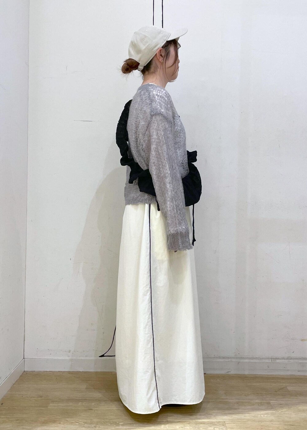 ブラック系のローファー、ホワイト系のスカート、グレー系のニット/セーターを着用したレディースの秋コーディネートの3枚目の写真