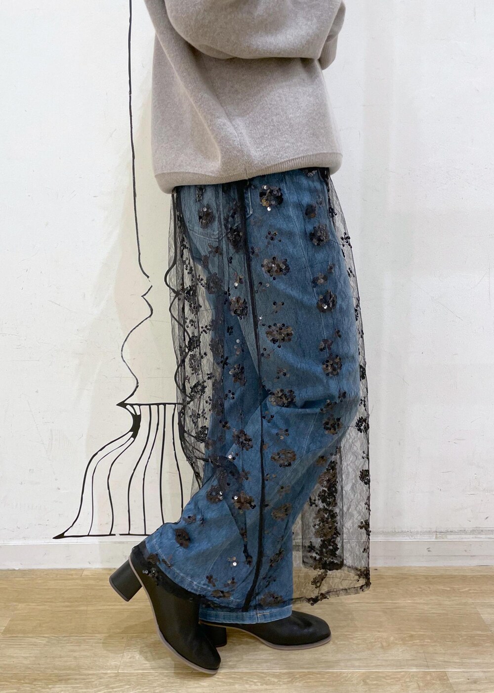 ブラック系のスカート、グレー系のニット/セーター、ブラック系のブーツを着用したレディースの秋コーディネートの7枚目の写真