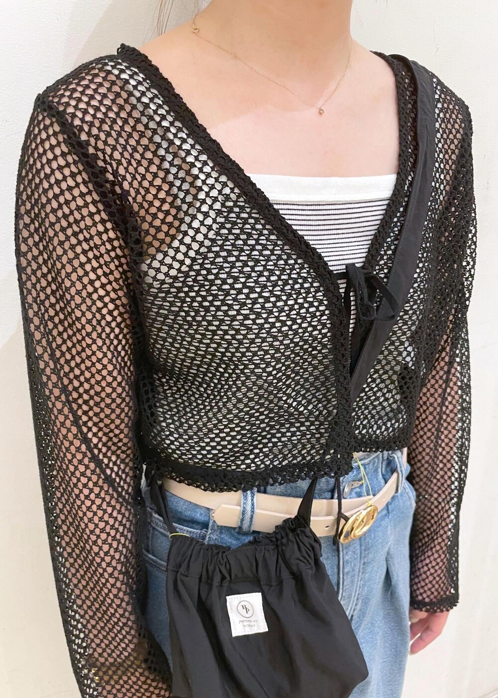 シルバー系のサンダル、ブラック系のショルダーバッグ、ホワイト系のタンクトップを着用したレディースの夏コーディネートの5枚目の写真