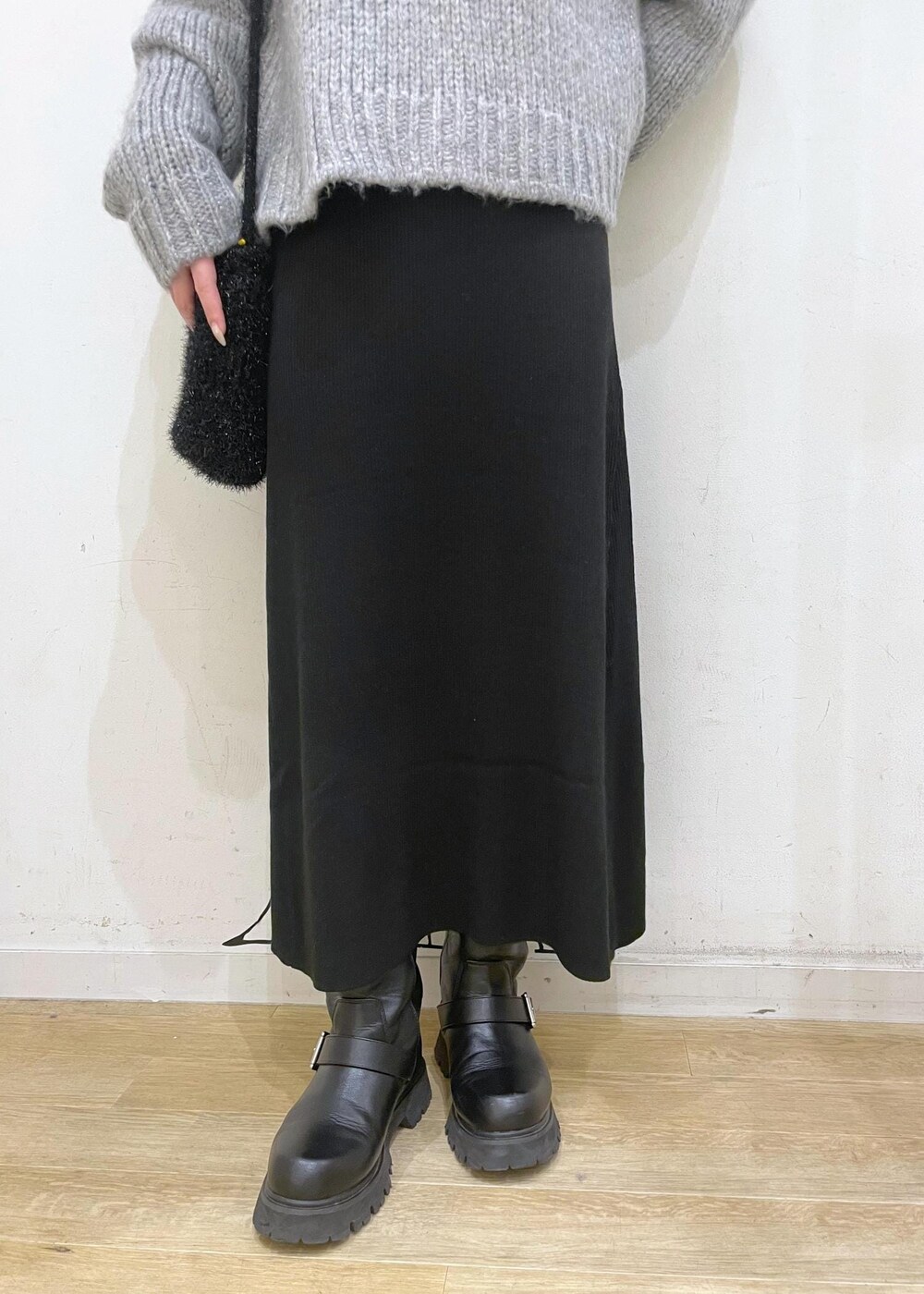 ブラック系のワンピース、ブラック系のショルダーバッグ、グレー系のニット/セーターを着用したレディースの冬コーディネートの7枚目の写真