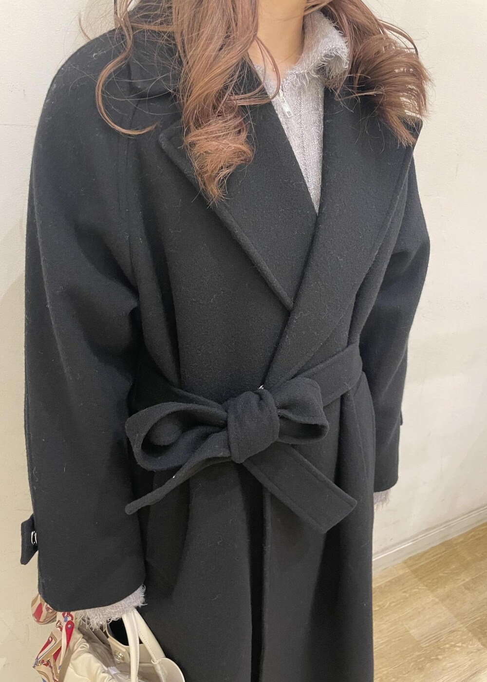 ブラウン系のローファー、グレー系のスカート、ブラック系のチェスターコートを着用したレディースの冬コーディネートの5枚目の写真