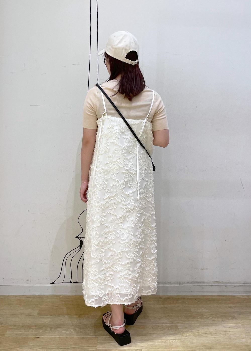 ホワイト系のサンダル、ホワイト系のワンピース、ブラック系のショルダーバッグを着用したレディースの夏コーディネートの3枚目の写真