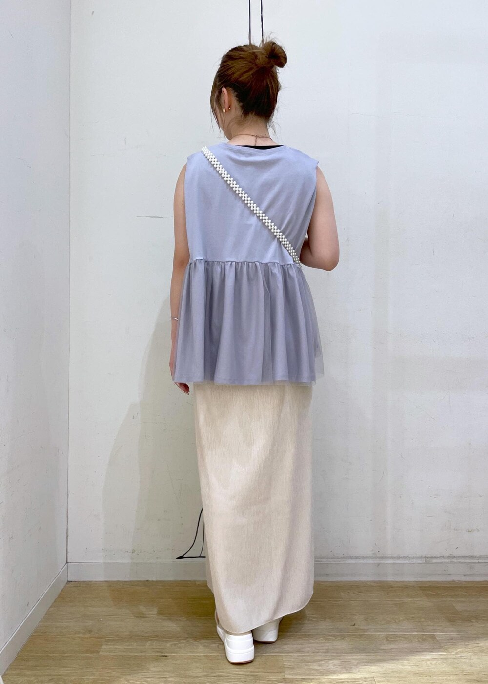 ベージュ系のスカート、ブルー系のTシャツ/カットソー、ホワイト系のサンダルを着用したレディースの夏コーディネートの2枚目の写真