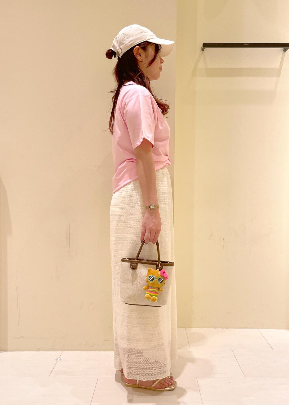 ホワイト系のスカート、ゴールド系のサンダル、ブラウン系のトートバッグを着用したレディースの夏コーディネートの4枚目の写真