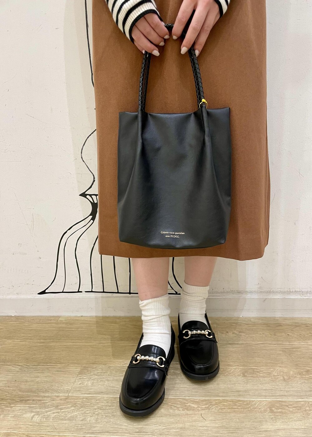 ホワイト系のニット/セーター、ブラウン系のジャンパースカート、ブラック系のローファーを着用したレディースの冬コーディネートの4枚目の写真