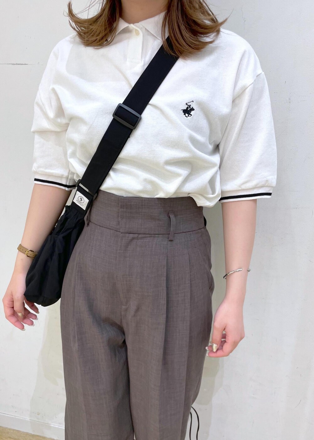 ブラウン系のその他パンツ、ブラック系のサンダル、ホワイト系のポロシャツを着用したレディースの春コーディネートの8枚目の写真