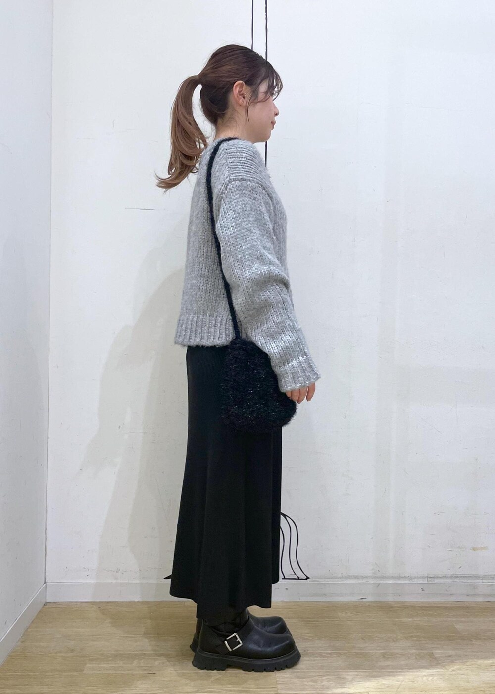 ブラック系のワンピース、ブラック系のショルダーバッグ、グレー系のニット/セーターを着用したレディースの冬コーディネートの3枚目の写真