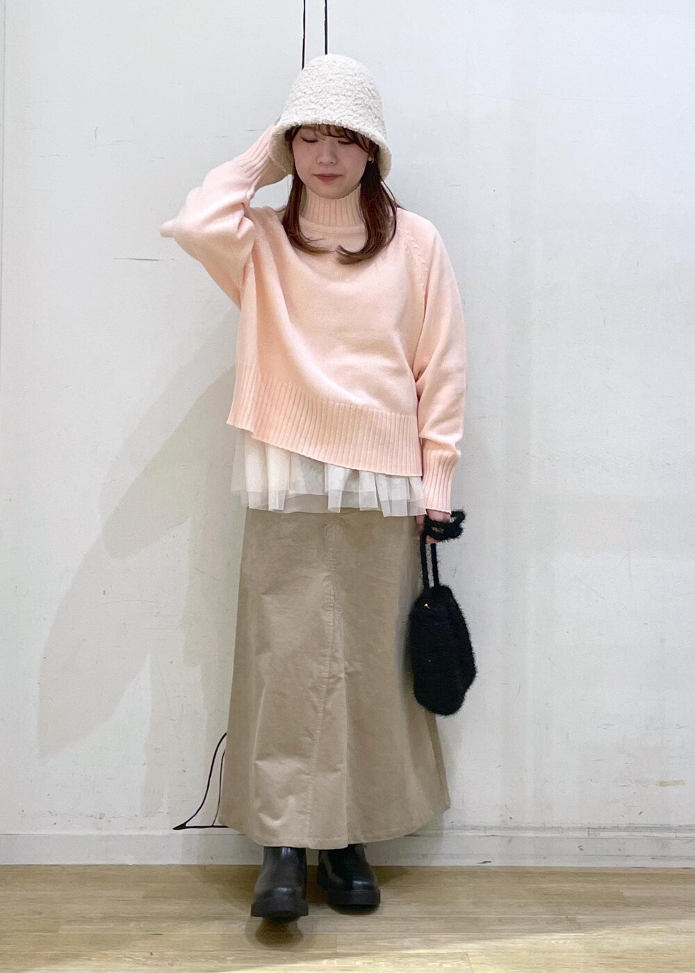 ピンク系のニット/セーター、ブラック系のブーツ、ブラック系のショルダーバッグを着用したレディースの冬コーディネートの10枚目の写真