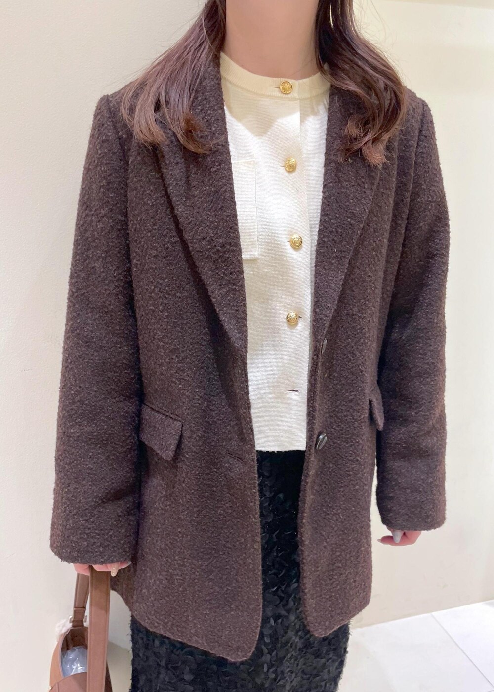 ホワイト系のカーディガン/ボレロ、ブラック系のブーツ、ブラウン系のテーラードジャケットを着用したレディースの秋コーディネートの5枚目の写真