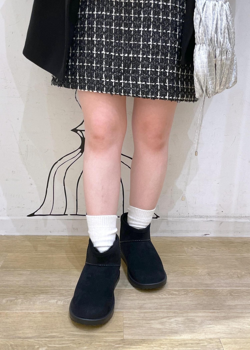 ブラック系のスカート、グレー系のニット/セーター、シルバー系のショルダーバッグを着用したレディースの冬コーディネートの7枚目の写真