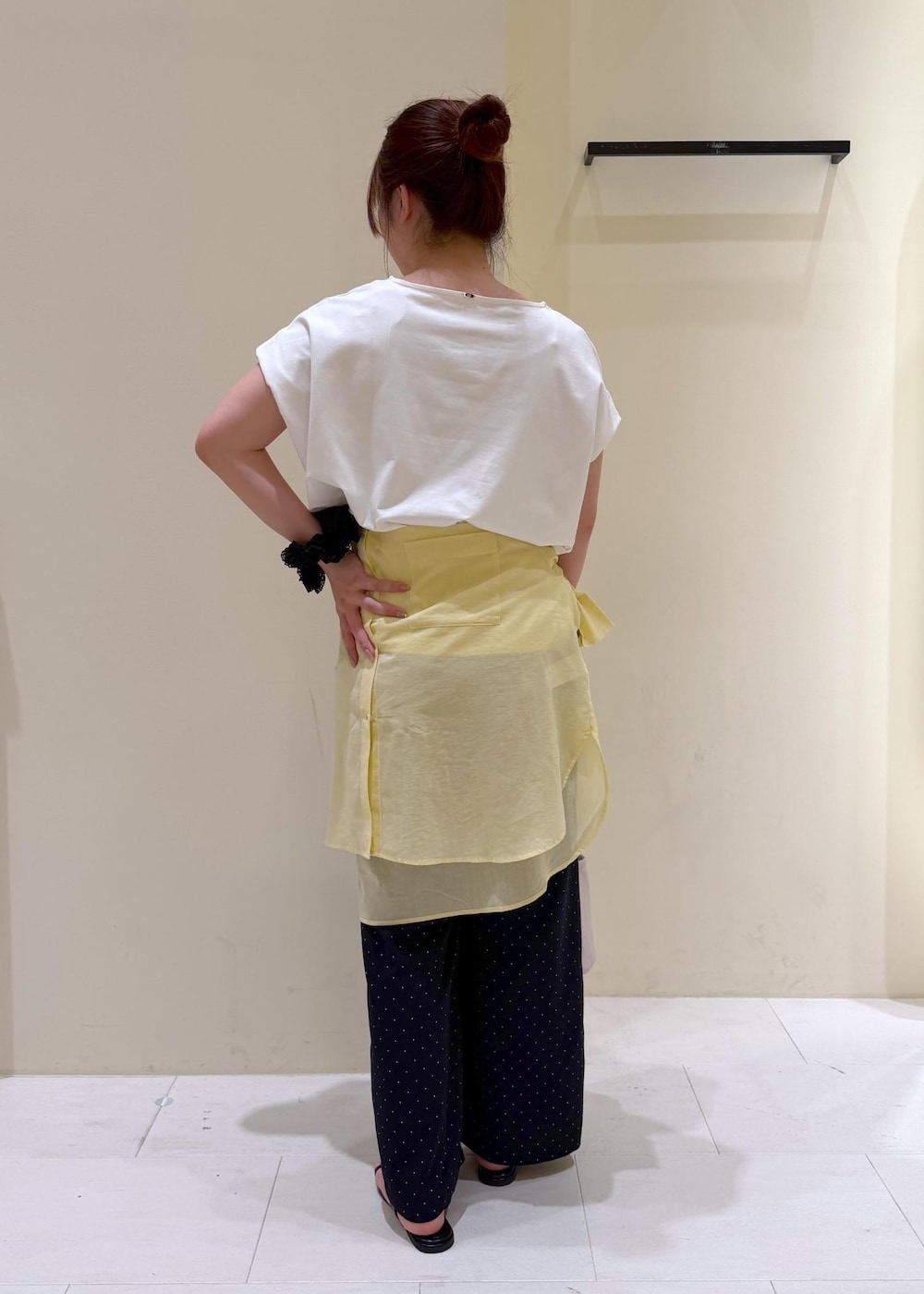 ブラック系のショルダーバッグ、イエロー系のシャツ/ブラウス、ホワイト系のTシャツ/カットソーを着用したレディースの夏コーディネートの3枚目の写真