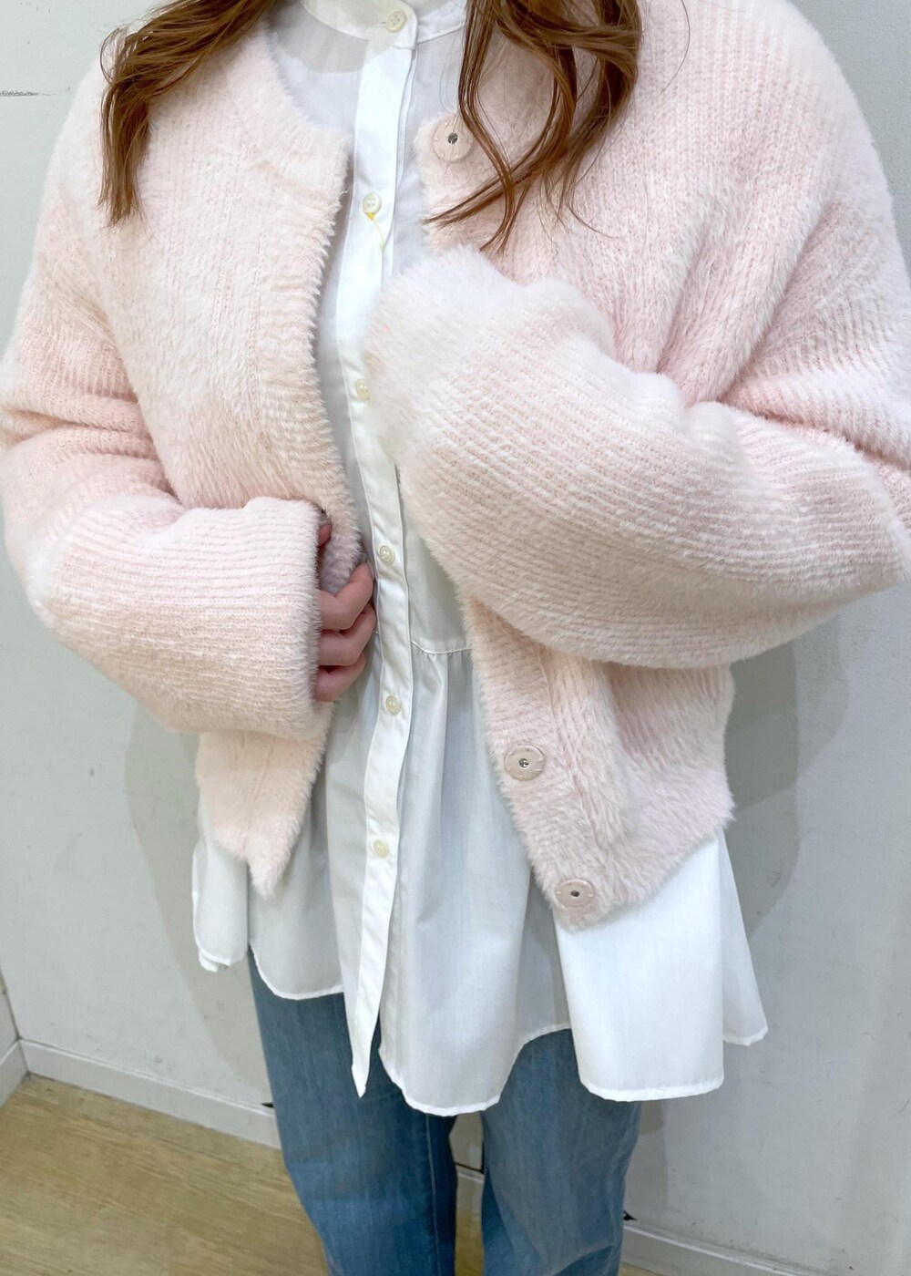 ブルー系のデニムパンツ、ホワイト系のショルダーバッグ、ホワイト系のパンプスを着用したレディースの冬コーディネートの9枚目の写真