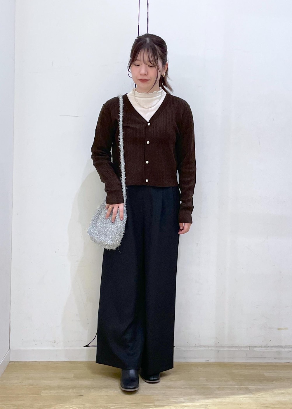 ホワイト系のTシャツ/カットソー、ブラック系のブーツ、ブラウン系のカーディガン/ボレロを着用したレディースの秋コーディネートの4枚目の写真