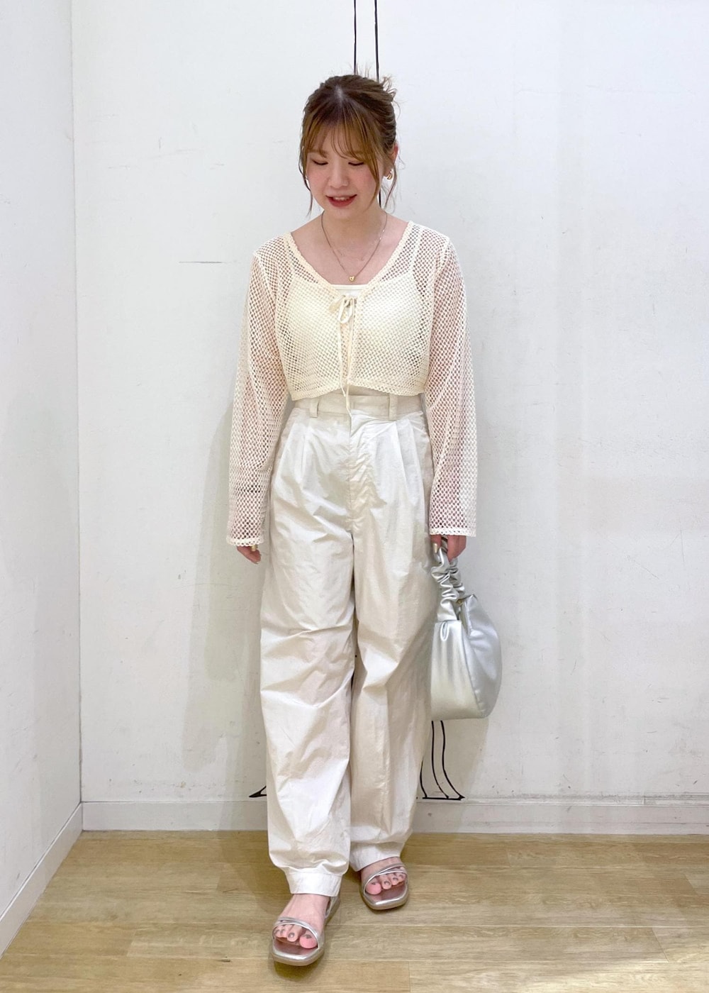 シルバー系のサンダル、シルバー系のハンドバッグ、ホワイト系のその他パンツを着用したレディースの夏コーディネートの4枚目の写真