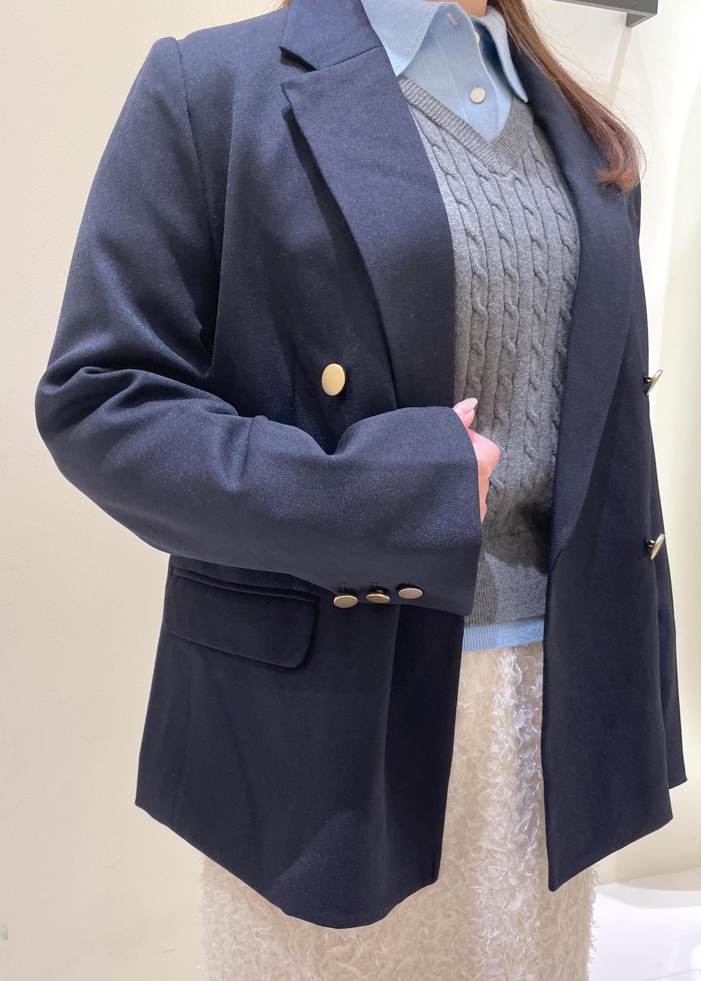 ブラック系のショルダーバッグ、ホワイト系のスカート、ブラック系のローファーを着用したレディースの秋コーディネートの7枚目の写真