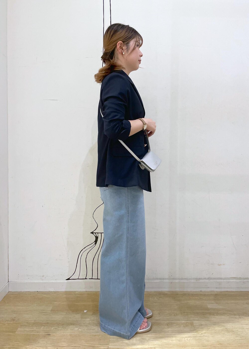 ブルー系のデニムパンツ、シルバー系のサンダル、ホワイト系のニット/セーターを着用したレディースの夏コーディネートの3枚目の写真