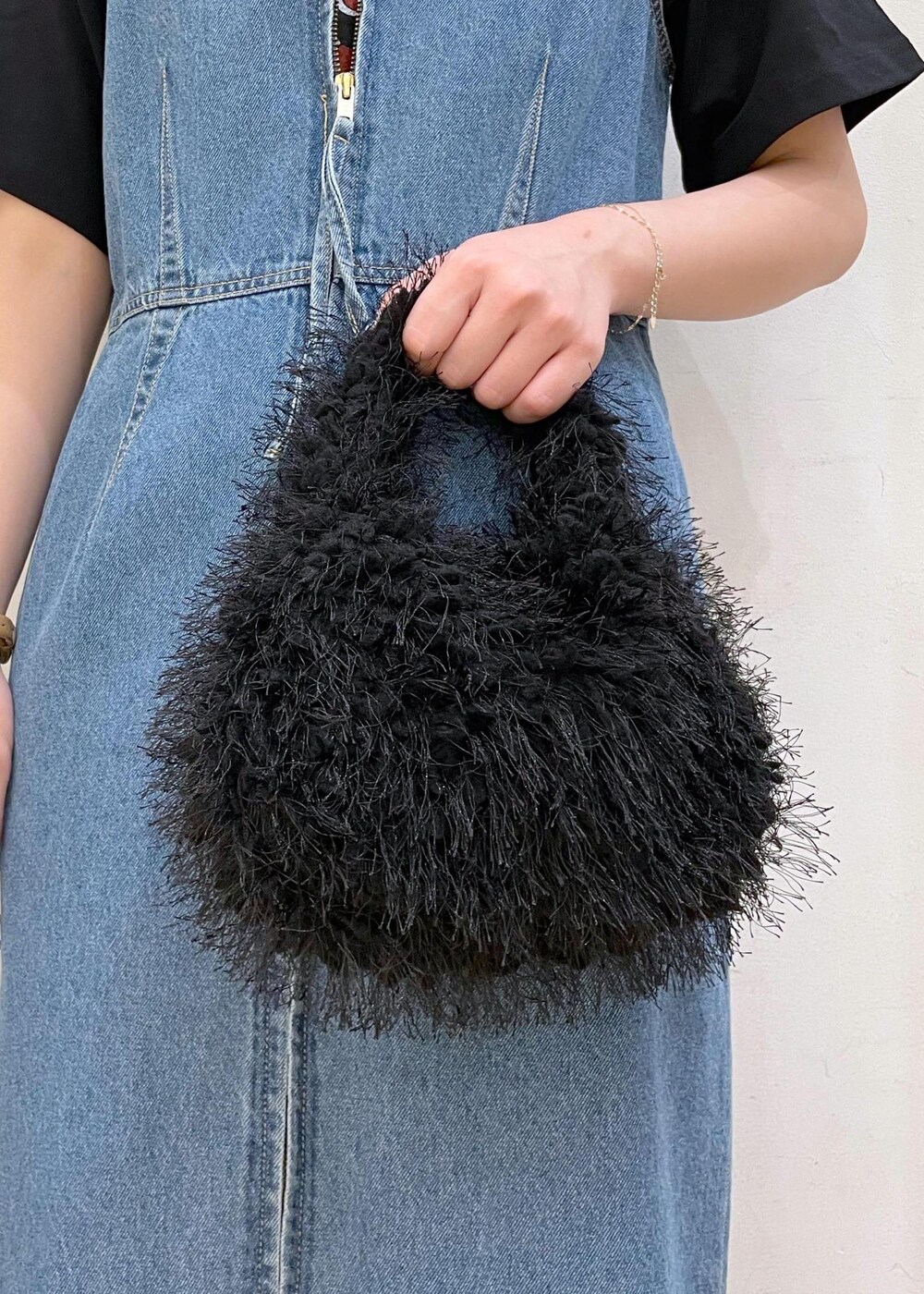 ホワイト系のスニーカー、ブラック系のハンドバッグ、ブルー系のジャンパースカートを着用したレディースの夏コーディネートの7枚目の写真