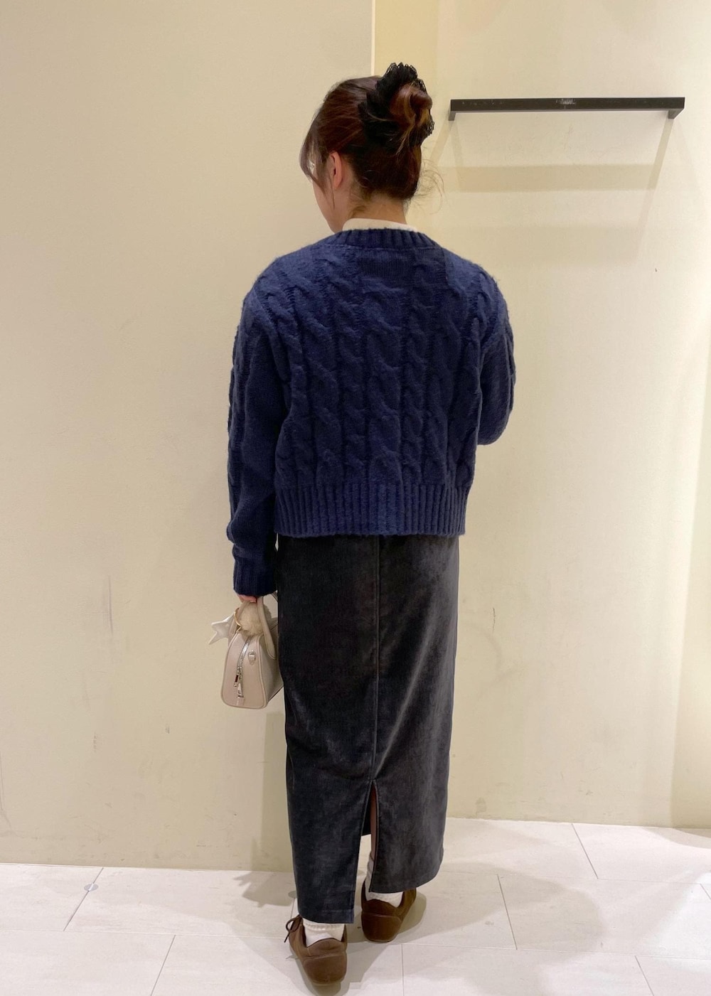 グレー系のスカート、ブルー系のカーディガン/ボレロ、ホワイト系のニット/セーターを着用したレディースの冬コーディネートの3枚目の写真