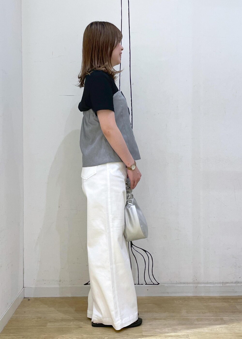 ブラック系のTシャツ/カットソー、ブラック系のサンダル、ホワイト系のデニムパンツを着用したレディースの春コーディネートの3枚目の写真