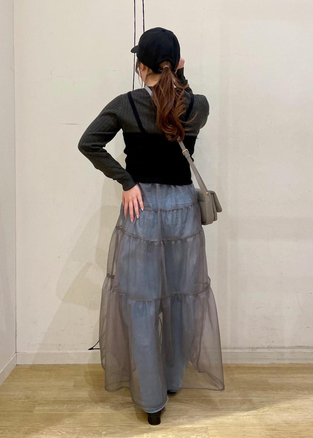 グレー系のショルダーバッグ、ブラック系のベスト、グレー系のニット/セーターを着用したレディースの春コーディネートの2枚目の写真