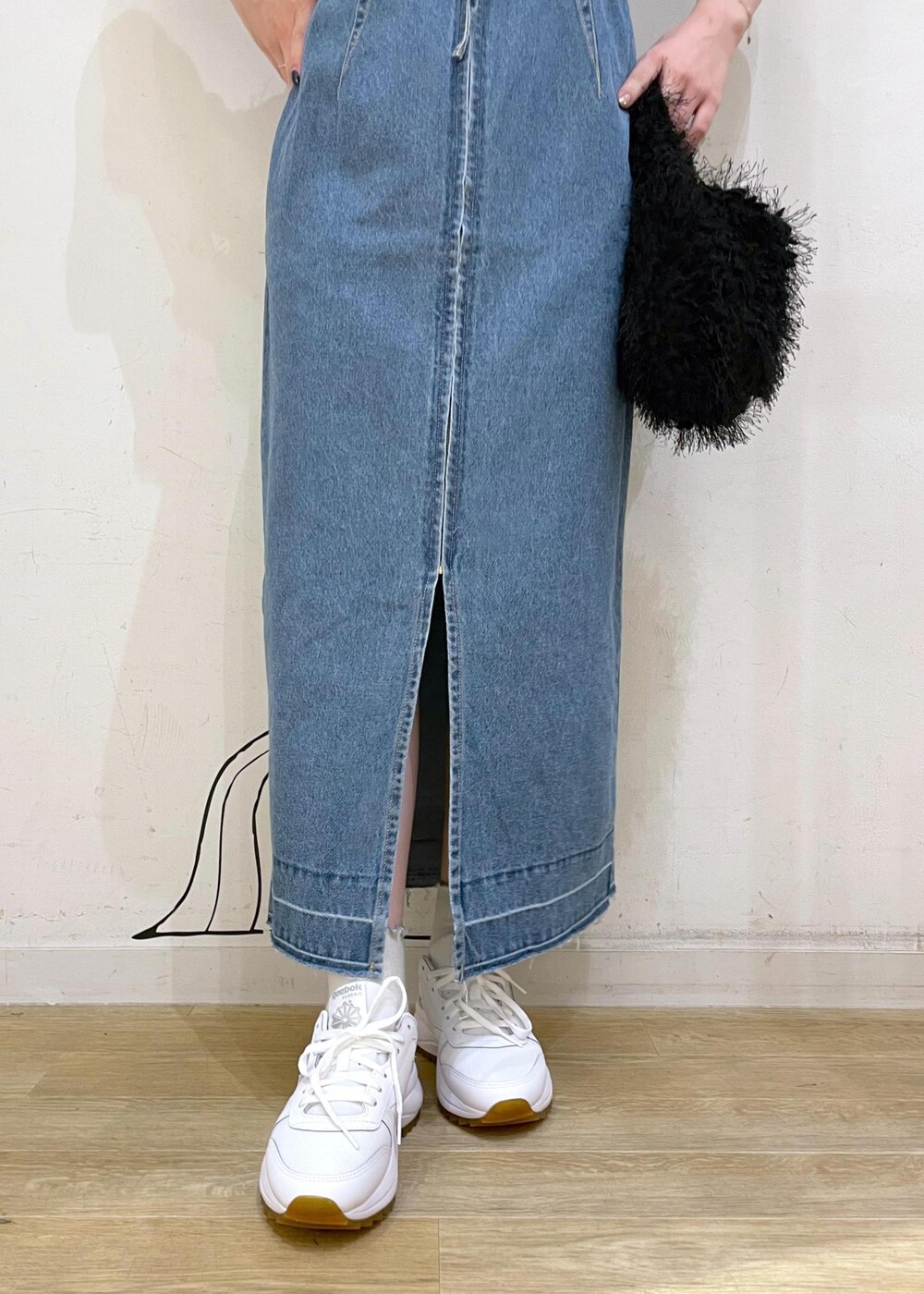 ホワイト系のスニーカー、ブラック系のハンドバッグ、ブルー系のジャンパースカートを着用したレディースの夏コーディネートの6枚目の写真