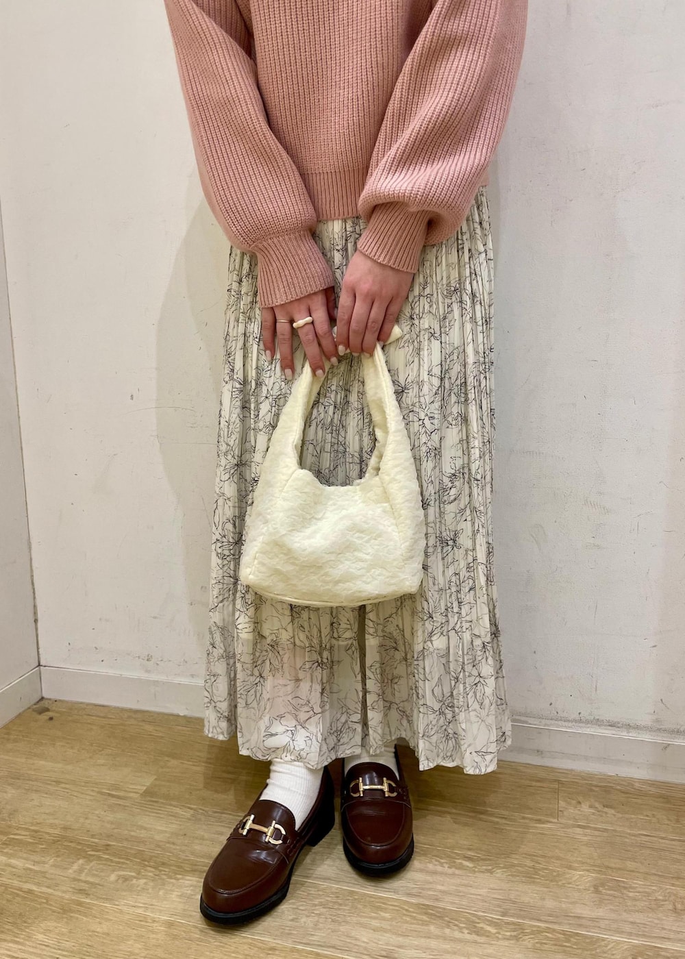 ホワイト系のスカート、ブラウン系のローファー、ホワイト系のショルダーバッグを着用したレディースの冬コーディネートの3枚目の写真