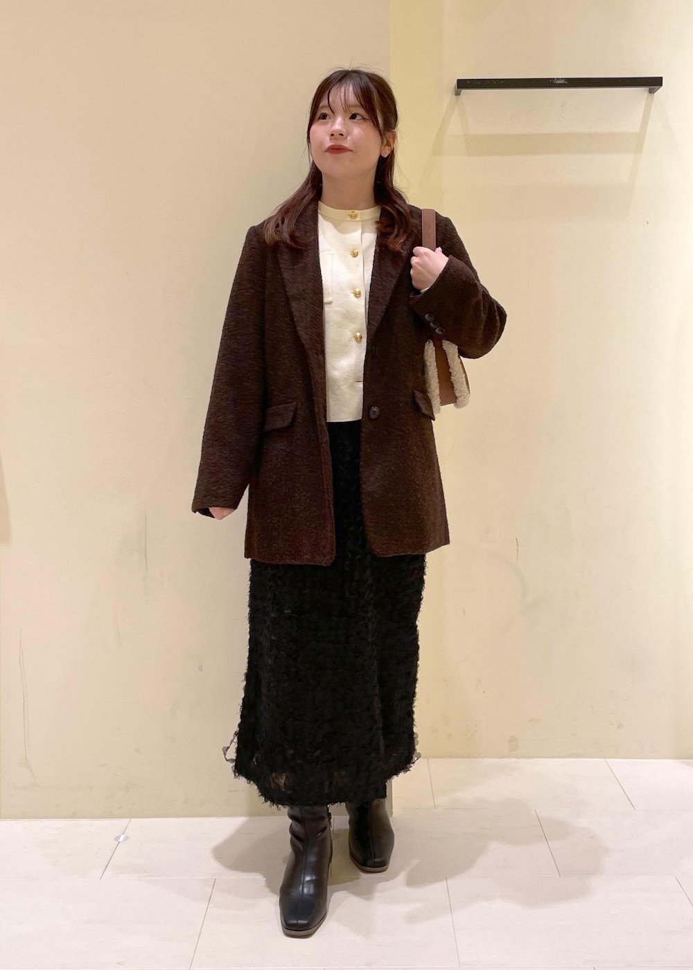 ホワイト系のカーディガン/ボレロ、ブラック系のブーツ、ブラウン系のテーラードジャケットを着用したレディースの秋コーディネートの4枚目の写真