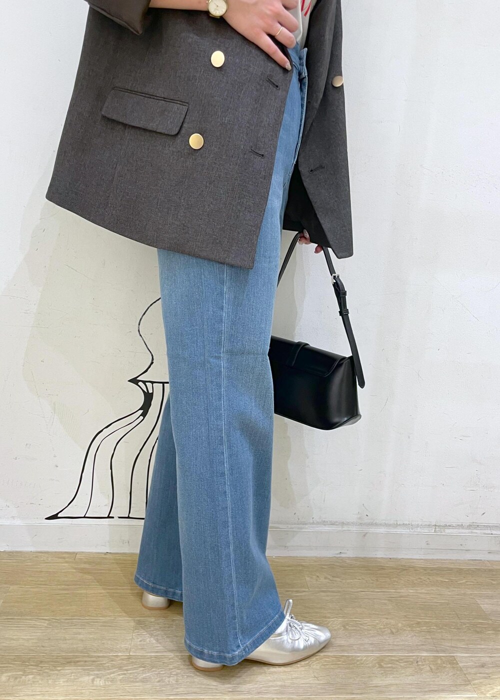 シルバー系のパンプス、ブルー系のデニムパンツ、ブラウン系のテーラードジャケットを着用したレディースの秋コーディネートの7枚目の写真