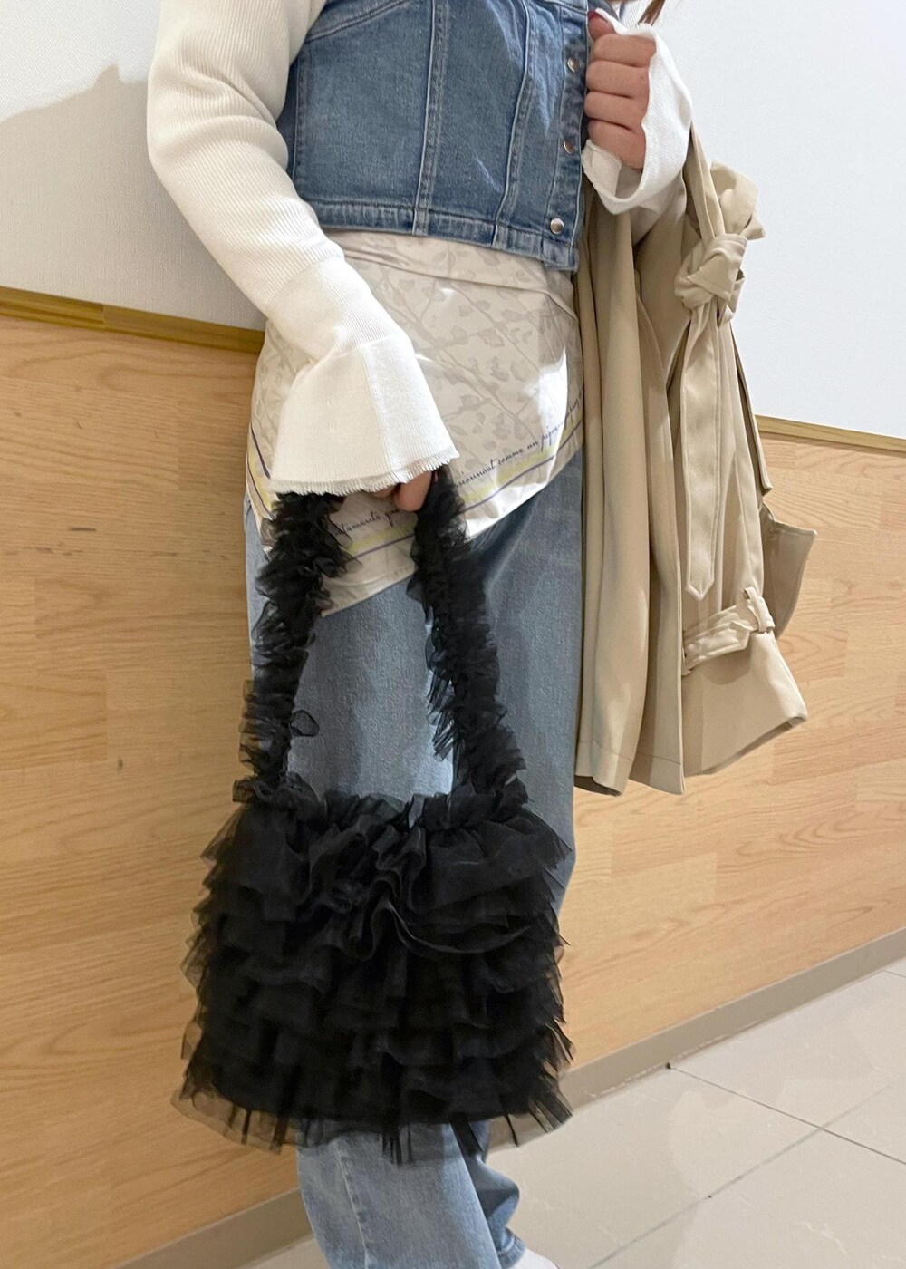 ブルー系のベスト、ホワイト系のニット/セーター、ベージュ系のトレンチコートを着用したレディースの春コーディネートの7枚目の写真