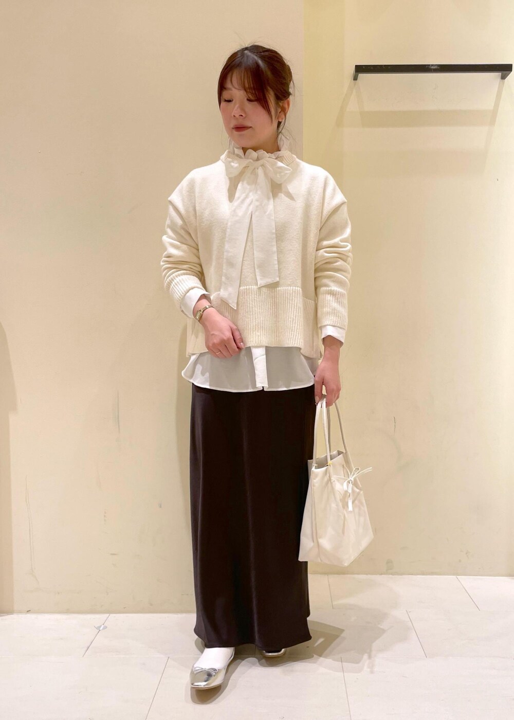 シルバー系のバレエシューズ、ホワイト系のニット/セーター、ホワイト系のトートバッグを着用したレディースの冬コーディネートの9枚目の写真
