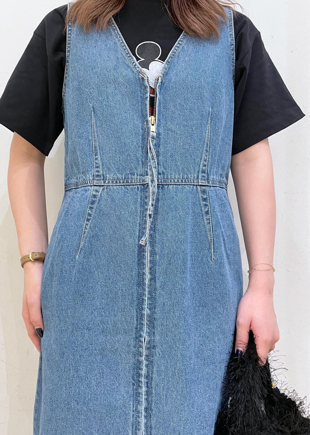 ホワイト系のスニーカー、ブラック系のハンドバッグ、ブルー系のジャンパースカートを着用したレディースの夏コーディネートの5枚目の写真