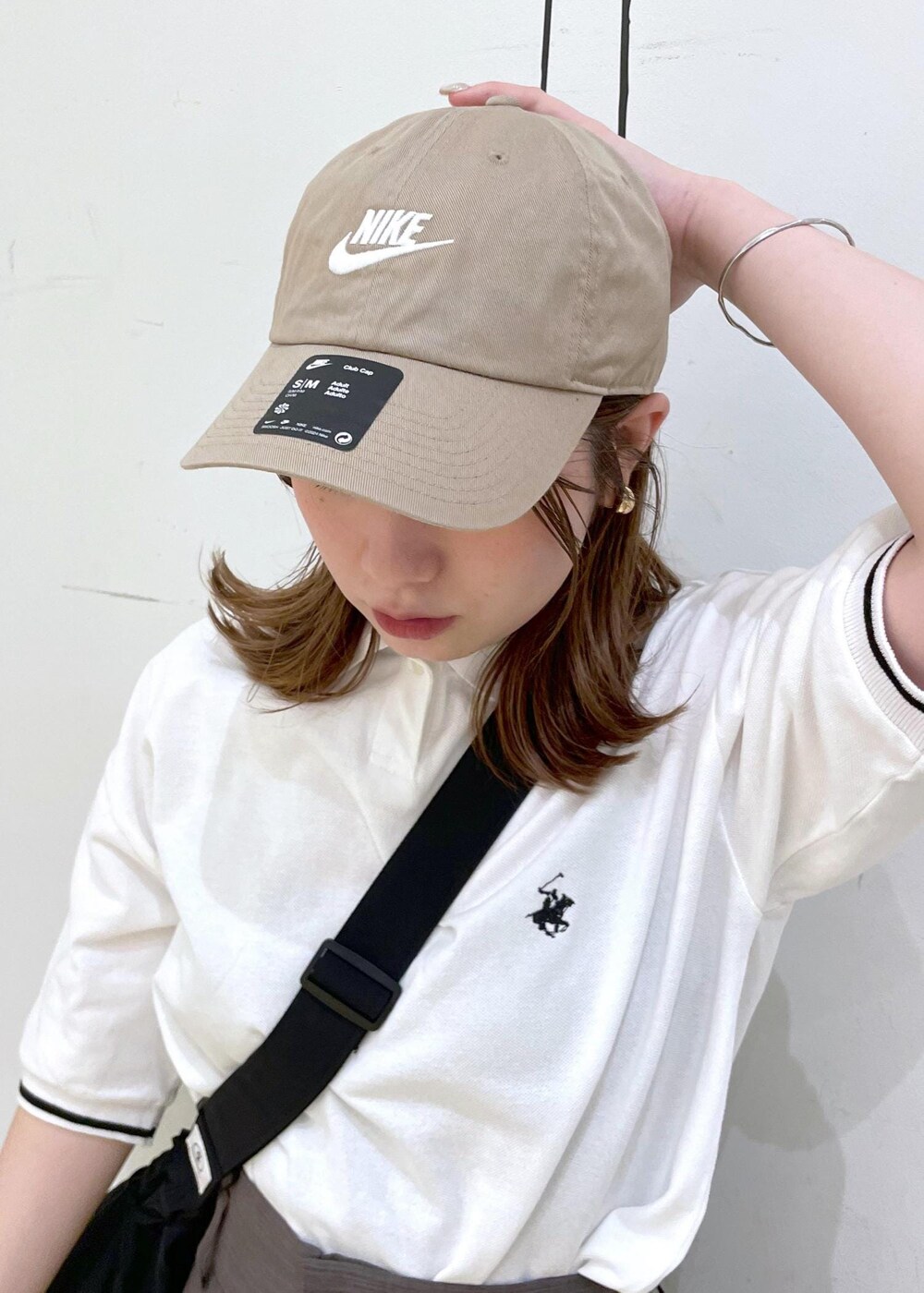 ブラウン系のその他パンツ、ブラック系のサンダル、ホワイト系のポロシャツを着用したレディースの春コーディネートの6枚目の写真